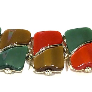 Könnte beinhalten: Ein farbenfrohes Armband mit rechteckigen Gliedern in Rot, Orange, Grün und Braun. Die Glieder sind durch silberfarbene Metallakzente verbunden. Ein auffälliges Schmuckstück.