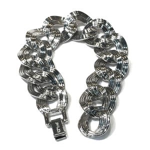 Könnte beinhalten: Ein silberfarbenes Armband mit Kettengliedern und strukturierter Oberfläche. Das Armband hat große, ineinandergreifende Glieder und einen Verschluss. Der Schmuck wird vor weißem Hintergrund gezeigt.