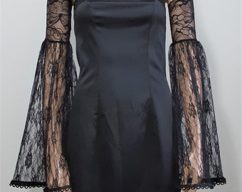 May include: A black strapless dress with black lace bell sleeves. The dress is made of a smooth, satin-like fabric.