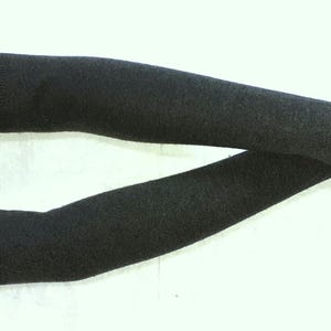 Peut inclure: Une paire de chauffe-bras noirs en tissu tricoté doux. Les chauffe-bras sont longs et atteignent le coude. Ils ont un trou pour le pouce à l'extrémité de chaque chauffe-bras.