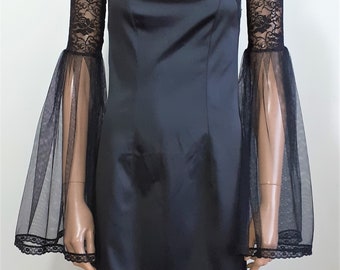 May include: Black strapless dress with sheer black lace bell sleeves. The sleeves have a scalloped edge and are made of a delicate, flowing fabric.