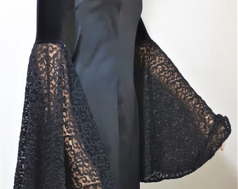 May include: A black strapless dress with a fitted bodice and a flared skirt. The dress has long, bell-shaped sleeves made of black lace.