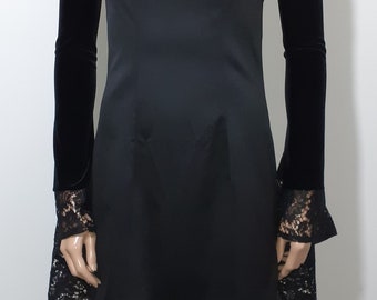 May include: A black strapless dress with a satin bodice and lace trim on the sleeves. The sleeves are made of black velvet with lace detailing at the cuffs.