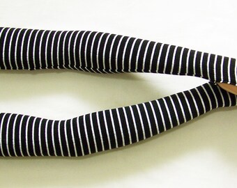 May include: A pair of black and white striped arm warmers with fingerless gloves. The arm warmers are made of a soft, stretchy fabric and are perfect for keeping your arms warm in the cooler months.