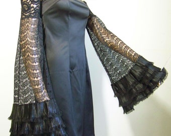 May include: Black off-the-shoulder dress with long, black lace sleeves that have ruffles at the ends.
