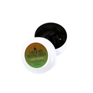 May include: A white, round container with an open lid, revealing black incense cones. The container has a label with the text "EARTH MIX INCENSE CONES" in green and orange. The label also lists the ingredients and origin.
