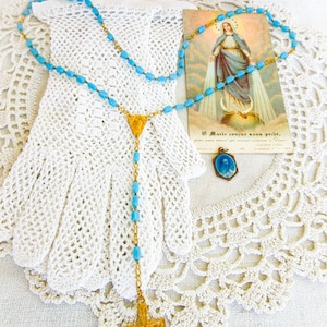 Cadeau eerste communie, set van 4 items, kanten handschoenen, rozenkrans, blauw geëmailleerde bedel van de heilige Theresia, kaart Miraculeuze Maria