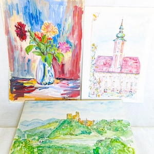 May include: Three watercolor paintings. One depicts a vase of flowers with a colorful background. Another shows a building with a pink roof and a tall steeple. The third painting is a landscape with a castle.