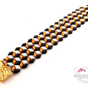 May include: A geometric bracelet with a repeating pattern of black, white, and gold beads. The bracelet has a gold clasp with an ornate design. The bracelet is a piece of jewellery.