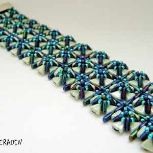Könnte beinhalten: Ein Armband mit einem silbernen Verschluss. Das Armband ist aus hellgrünen und irisierenden blauen Perlen in einem geometrischen Muster gefertigt.