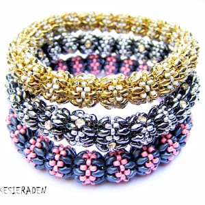May include: Three beaded bracelets stacked on top of each other. The top bracelet is gold with white beads, the middle bracelet is black and silver with clear rhinestones, and the bottom bracelet is black with pink beads.