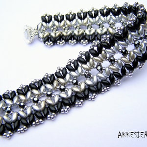 May include: A black and silver beaded bracelet with a geometric pattern. The bracelet is made with small, round beads and has a clasp closure.