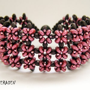 Op de afbeelding: Een close-up van een kralenarmband met een herhalend patroon van bordeauxrode en bruine kralen. De armband is gemaakt met kleine, ronde kralen die samen geweven zijn om een ​​bloemmotief te creëren.