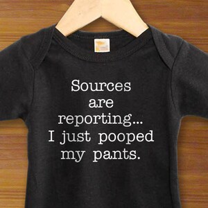 May include: Black baby onesie with white text that reads "Sources are reporting... I just pooped my pants."