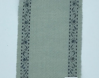 May include: A sample of light gray fabric with a black and white patterned border. The fabric has a woven texture and a slightly frayed edge. The sample is labeled with the text "#3-1-5" and "#22-."