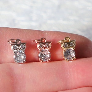 Puede incluir: Tres dijes de b&uacute;ho con detalles de cristal transparente. Los dijes son de plata, oro rosa y oro.