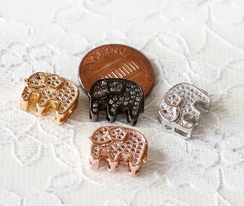 Puede incluir: Cuatro abalorios de elefante, cada uno con un acabado met&aacute;lico diferente: dorado, negro, plateado y oro rosa. Cada abalorio est&aacute; cubierto de peque&ntilde;os diamantes de imitaci&oacute;n transparentes.