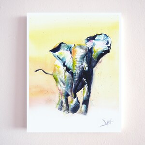 May include: Watercolor painting of a blue and green elephant with a yellow background. The elephant is walking towards the viewer with its trunk raised.