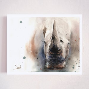 May include: A watercolor painting of a white rhinoceros with a brown and gray background. The rhinoceros is facing the viewer with its mouth closed. The painting has a light, airy feel.