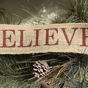 May include: A burlap banner with the word "BELIEVE" printed in red.