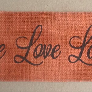 Può includere: Striscione in juta arancione con il testo "Live Love Laugh" in lettere corsive nere.