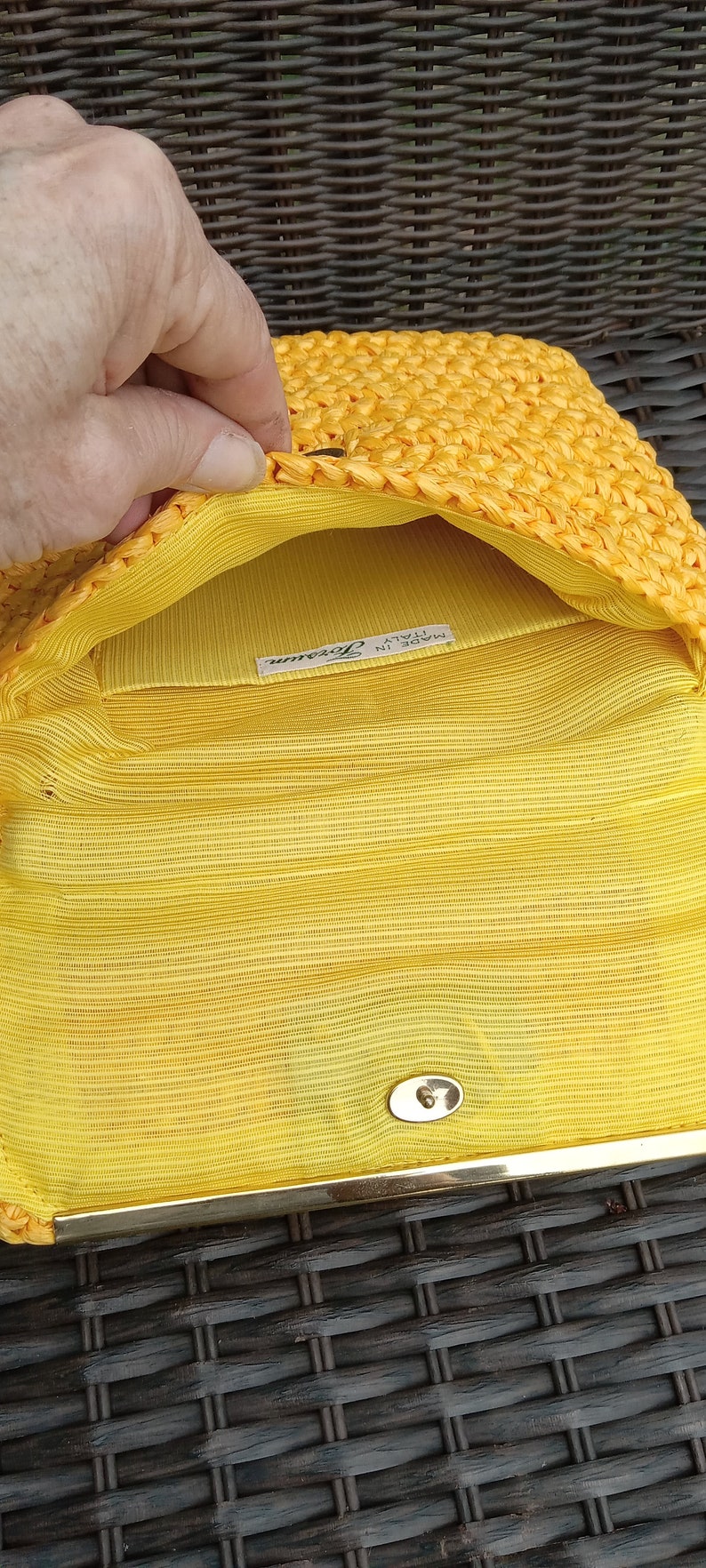 Pode incluir: Clutch de tecido amarelo com fecho dourado e uma etiqueta que diz "Feito na It&aacute;lia, Lorenza".