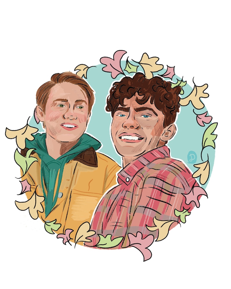 May include: Two men smiling at the camera, framed by a circle of colorful leaves. The man on the left is wearing a yellow jacket over a green hooded sweatshirt. The man on the right is wearing a red and black plaid shirt.