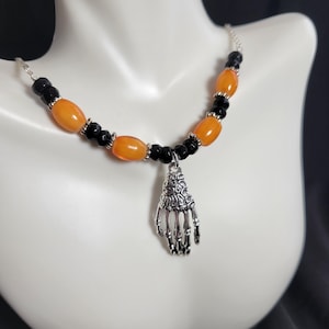 Skeleton hand Halloween black, orange, and silver chain pendant necklace