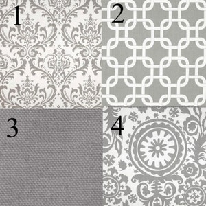 May include: Four fabric swatches in gray and white with numbers 1 through 4.  Swatch 1 has a white background with a gray damask pattern. Swatch 2 has a gray background with a white geometric pattern. Swatch 3 has a solid gray background with a subtle texture. Swatch 4 has a white background with a gray floral pattern.