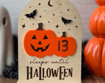 May include: A wooden Halloween countdown sign with a carved pumpkin and bats. The sign says "sleeps until HALLOWEEN" and features a pumpkin with the number 13.