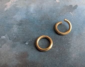 May include: Two gold-colored metal jump rings. The rings are open and ready to be used for jewelry making or other crafts.