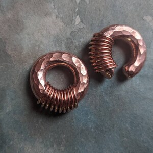 Puede incluir: Dos medidores de oreja de cobre martillados con un dise&ntilde;o de alambre en espiral. Los medidores son de color oro rosa.