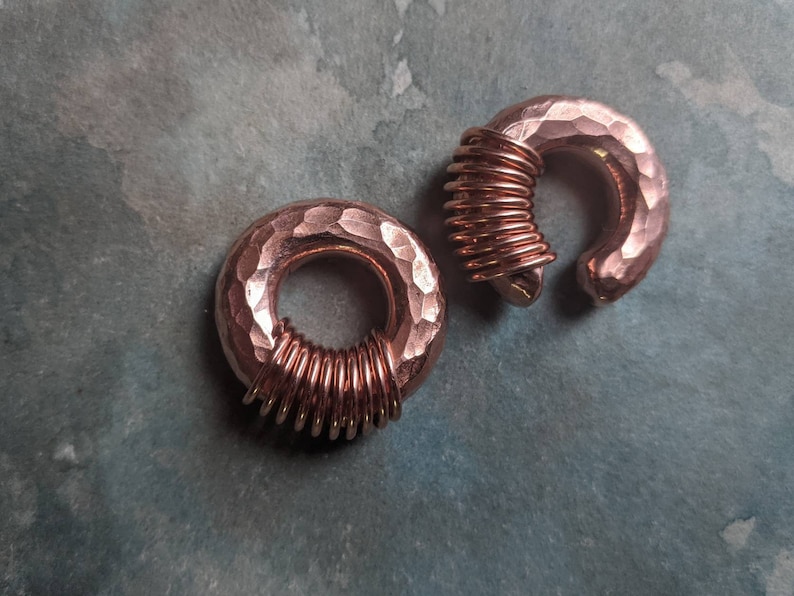 Puede incluir: Dos medidores de oreja de cobre martillados con un dise&ntilde;o de alambre en espiral. Los medidores son de color oro rosa.