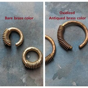 Puede incluir: Dos anillos de lat&oacute;n con un dise&ntilde;o de alambre en espiral. El anillo de la izquierda es de lat&oacute;n desnudo, mientras que el anillo de la derecha est&aacute; oxidado, lo que le da un aspecto antiguo.