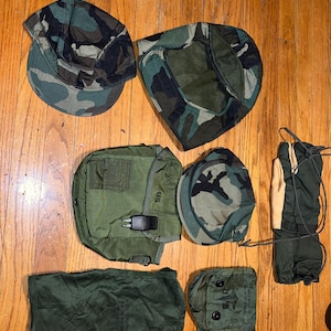 May include: A collection of military surplus items including a green camouflage utility pouch, a green camouflage first aid kit, a green camouflage canteen cover, a green camouflage hat, a green camouflage boonie hat, and a pair of green camouflage gloves.