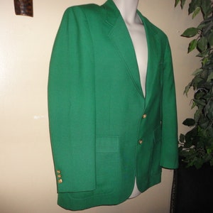 May include: A solid green blazer with gold buttons. The blazer has a single button closure and two pockets.