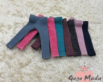 May include: A set of eight pairs of denim pants in various colors, including gray, pink, teal, burgundy, black, and light pink. The pants are all made of a soft, stretchy denim fabric and have a relaxed fit.