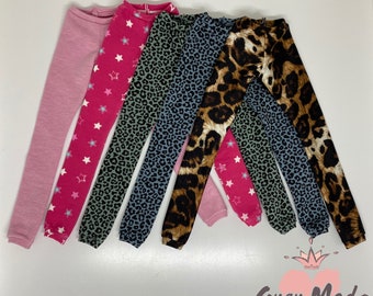 Peut inclure: Cinq paires de leggings dans différents motifs. Une paire est rose unie, une paire a des étoiles roses sur fond blanc, une paire a un imprimé léopard vert et noir, une paire a un imprimé léopard bleu et noir et une paire a un imprimé léopard brun et noir.