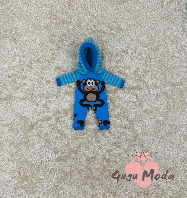 May include: Blue hooded baby onesie with a monkey graphic. The onesie has a striped pattern on the sleeves and legs.