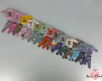 May include: A collection of 20 miniature doll outfits with various animal designs. The outfits are made of soft, colorful fabrics and feature striped pants and long-sleeved shirts.