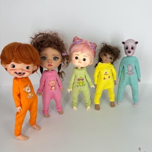 Puede incluir: Cinco muñecas con pijamas coloridos con diseños de animales. Las muñecas tienen diferentes colores y estilos de cabello. Las pijamas están hechas de tela suave y cómoda.