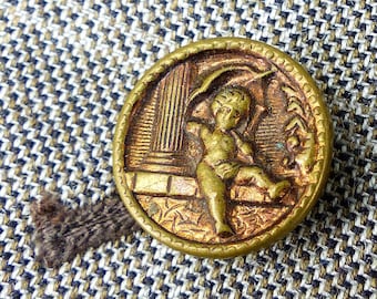 Circa 1900s antique cherub and greek column copper raised story button in bronze copper. Magnetic MagTAK lapel pin & tie tack