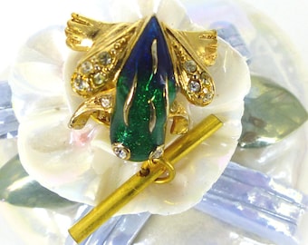Little green, blue enamel and gold frog with clear crystal eyes and legs. Push pin back with chain. Tie tack, lapel pin. Packaged as a gift.