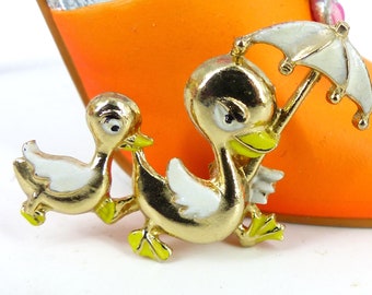 Heartwarming pin mama and duckling out for a stroll with mama holding the umbrella White and yellow enamel latch pin. Packaged as a gift