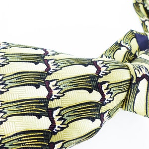 May include: A yellow silk tie with a green and black abstract pattern.