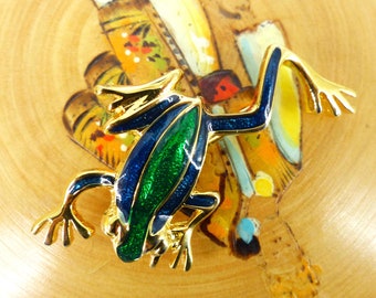 Cool little enamel frog brooch with latch pin back. Gold design with details in blue and brilliant green. Packaged as a gift. Quality feel