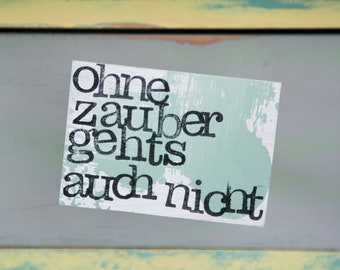 May include: A light green and white sign with black text that reads "ohne zauber gehts auch nicht".