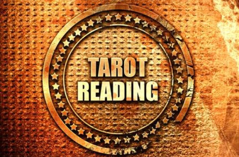 May include: A gold-colored circular sign with a distressed, textured background. The sign has a border of stars and the text "Tarot Reading" in bold, white letters.