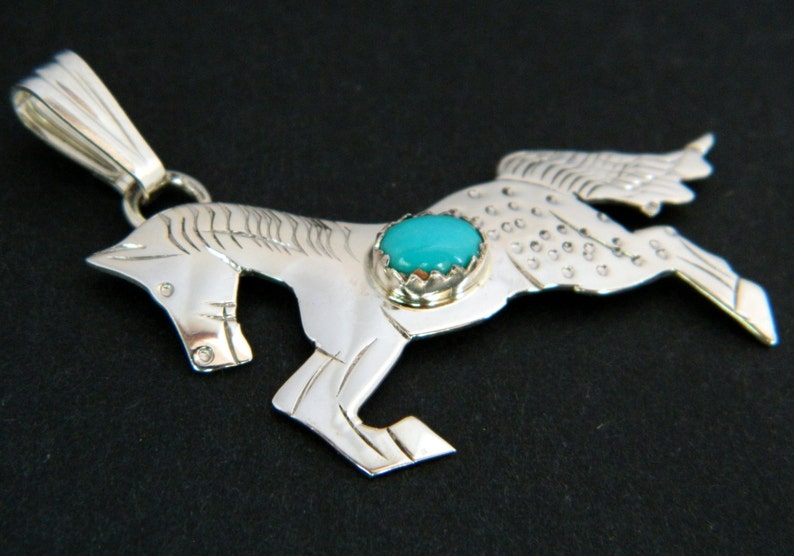 May include: Sterling silver pendant featuring a detailed horse design with a turquoise stone set in the center.