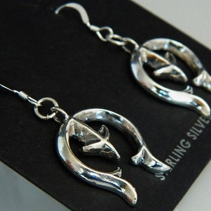 May include: Sterling silver earrings with a horseshoe design and a small arrow inside each horseshoe.